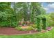 Lush landscaping with colorful flowers, decorative stone, and a charming birdhouse creating a tranquil garden retreat at 7018 Dowington Dr, Charlotte, NC 28277