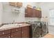 Functional laundry room with a utility sink, ample cabinet space, and modern washer and dryer at 7018 Dowington Dr, Charlotte, NC 28277