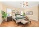 Serene main bedroom featuring a comfortable bed, hardwood floors, and ambient lighting at 7018 Dowington Dr, Charlotte, NC 28277