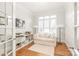 Bright office space featuring hardwood floors, white trim, built-in shelves, and a comfortable seating area at 7018 Dowington Dr, Charlotte, NC 28277