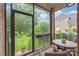 Cozy screened porch with wicker seating, a patterned rug, and views of the lush backyard, perfect for relaxing at 7018 Dowington Dr, Charlotte, NC 28277
