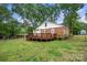 Exterior view of charming brick home featuring a spacious deck and landscaped backyard, perfect for outdoor living at 725 W Graham St, Shelby, NC 28150