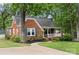 Quaint brick home featuring a cozy front porch and lush greenery surrounding the property at 725 W Graham St, Shelby, NC 28150
