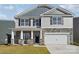 Two-story home showcasing stone accents, vertical siding, gray shingles and a two-car garage at 7909 Old Brook Rd, Sherrills Ford, NC 28673
