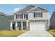 Two-story home showcasing stone accents, vertical siding, gray shingles and a two-car garage at 7909 Old Brook Rd, Sherrills Ford, NC 28673