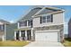 Two-story home showcasing stone accents, vertical siding, gray shingles and a two-car garage at 7909 Old Brook Rd, Sherrills Ford, NC 28673