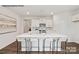 Bright, modern kitchen featuring a large island with seating, white cabinetry, and wood floors at 7913 Old Brook Dr, Sherrills Ford, NC 28673