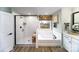 Bright bathroom features a tub, separate glass shower, wood tile floors, and modern finishes at 8004 Plymouth Dr, Sherrills Ford, NC 28673