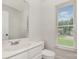 Standard bathroom featuring a neutral vanity, toilet, and window with blinds at 8429 Meadowcroft Ct, Charlotte, NC 28215