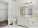 Bright bathroom featuring double sinks, a walk-in shower, and marble floors at 8429 Meadowcroft Ct, Charlotte, NC 28215
