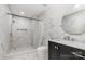 Modern bathroom featuring marble tile, walk-in shower, and dark vanity with round mirror at 8429 Meadowcroft Ct, Charlotte, NC 28215