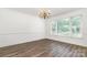 Dining room featuring wood-look floors, large window, and classic chandelier at 8429 Meadowcroft Ct, Charlotte, NC 28215