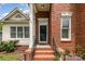 Inviting front entrance with brick steps, wrought iron railing, and a decorative glass door at 8429 Meadowcroft Ct, Charlotte, NC 28215