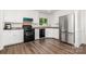 Bright kitchen with white cabinets, stainless steel appliances, and dark wood-look flooring at 8429 Meadowcroft Ct, Charlotte, NC 28215