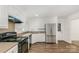 Bright kitchen featuring white cabinets, stainless appliances, and wood-look floors at 8429 Meadowcroft Ct, Charlotte, NC 28215