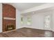 Bright living room featuring a brick fireplace, wood-look flooring, and a glass door at 8429 Meadowcroft Ct, Charlotte, NC 28215