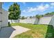 Backyard view featuring a concrete patio, a well-maintained lawn, and a white fence at 8605 Sawleaf Ct, Charlotte, NC 28215