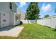 Backyard with a concrete patio, a well-maintained lawn, and a white fence at 8605 Sawleaf Ct, Charlotte, NC 28215