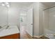 Clean bathroom featuring a shower-tub combo, wood-look floors, and a white vanity with sink at 8605 Sawleaf Ct, Charlotte, NC 28215