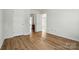 Spacious bedroom with wood floors, open doorways, and neutral paint at 8605 Sawleaf Ct, Charlotte, NC 28215