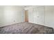 Clean and bright bedroom featuring neutral carpet, white walls and ample closet space at 8605 Sawleaf Ct, Charlotte, NC 28215