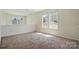 Upstairs bonus room featuring large windows and neutral carpet for a cozy feel at 8605 Sawleaf Ct, Charlotte, NC 28215