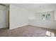 Empty bonus room features bright windows, neutral walls and carpet, and modern electrical outlets at 8605 Sawleaf Ct, Charlotte, NC 28215