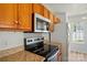 Close-up of updated kitchen appliances with wood cabinets and granite countertops at 8605 Sawleaf Ct, Charlotte, NC 28215