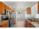Open kitchen with wood cabinets, granite counters, stainless steel appliances, and breakfast nook with natural light at 8605 Sawleaf Ct, Charlotte, NC 28215