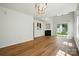 Open-concept living room with wood floors, a fireplace, and a sliding glass door to the backyard at 8605 Sawleaf Ct, Charlotte, NC 28215