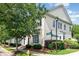 Charming townhome with light yellow siding, manicured landscaping, and beautiful mature trees at 939 White Point Dr, Huntersville, NC 28078