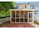 A beautiful outdoor patio with brick pavers, string lights, and a screened in porch at 939 White Point Dr, Huntersville, NC 28078