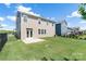 Expansive backyard featuring a black metal fence, lush green grass, and a patio with direct backyard access at 1004 Earlston Rd, Indian Trail, NC 28079