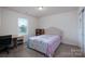 Bright bedroom featuring neutral walls, carpet flooring, a window, and a cozy bed with an upholstered headboard at 1004 Earlston Rd, Indian Trail, NC 28079
