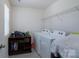Functional laundry room with modern washer and dryer, shelving, and neutral walls with tiled floors at 1004 Earlston Rd, Indian Trail, NC 28079
