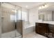 Bright bathroom featuring a tiled walk-in shower, soaking tub, and dark wood vanity with double sinks at 1020 Bannister Rd, Waxhaw, NC 28173
