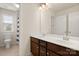 Bright bathroom with double sinks, cherry vanity cabinets, and a large mirror at 1020 Bannister Rd, Waxhaw, NC 28173