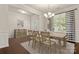 Bright dining area with elegant chandelier, wood floors, and modern striped curtains at 1020 Bannister Rd, Waxhaw, NC 28173