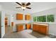 Bright dining area featuring wood cabinets, countertops, ceiling fan, and natural light from a large window at 1038 Blake Rd, Albemarle, NC 28001