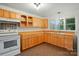 Bright kitchen featuring warm wooden cabinets, tile floors, and ample counter space at 1038 Blake Rd, Albemarle, NC 28001