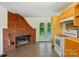 Bright kitchen featuring a brick fireplace, tile floors, and access to the backyard through french doors at 1038 Blake Rd, Albemarle, NC 28001