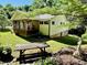 Backyard view showcasing a serene setting, mature trees, and picnic table for outdoor living at 105 Venus Ave, Gastonia, NC 28052