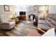 Comfortable living room with a brick fireplace, new wood-look flooring, and cozy seating arrangement at 105 Venus Ave, Gastonia, NC 28052