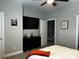 Modern bedroom with a sleek black dresser, mounted TV, and neutral gray walls and ceiling fan at 110 W Pine St, Lincolnton, NC 28092