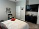 Bedroom featuring black dresser, mounted TV, neutral gray walls and a chair at 110 W Pine St, Lincolnton, NC 28092