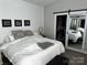 Comfortable bedroom featuring a large bed, shiplap wall detail, and closet with a sliding mirrored door at 110 W Pine St, Lincolnton, NC 28092