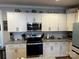 Modern kitchen featuring white cabinets, granite countertops, and stainless steel appliances at 110 W Pine St, Lincolnton, NC 28092