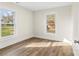 Bright bedroom boasts wood-look floors, neutral walls, and lots of natural light from two windows at 1102 Venus St, Kannapolis, NC 28083