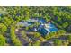 Aerial view of a community center with tennis courts and a pool, surrounded by lush trees and ample parking at 11209 Flenniken Ct, Charlotte, NC 28277