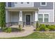 Welcoming front porch featuring stone accents, a well-maintained lawn, and attractive landscaping enhancing the entrance at 11209 Flenniken Ct, Charlotte, NC 28277